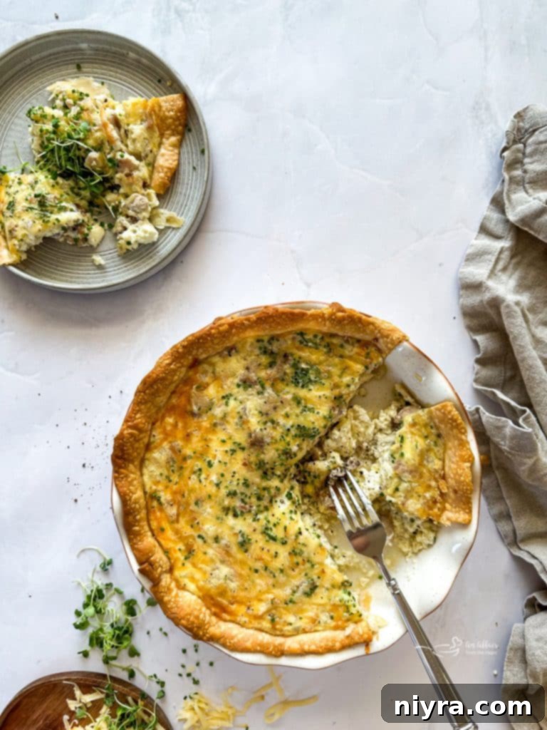 A slice of Smoked Ham and Gouda Quiche with a flaky crust.