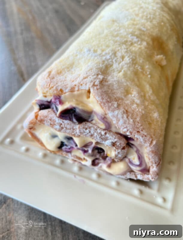 Spreading a layer of blueberry pie filling onto the unrolled angel food cake