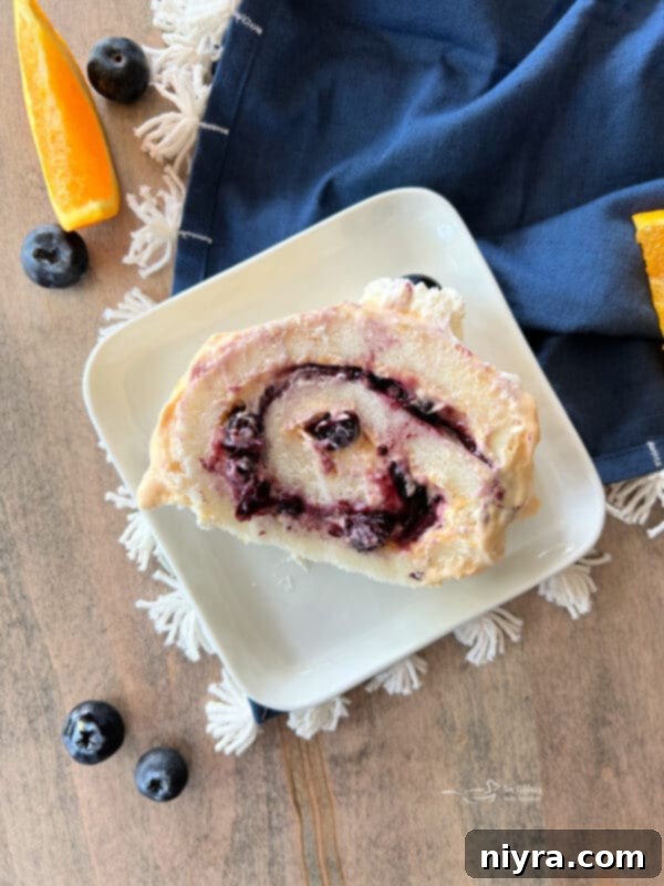Blueberry Orange Angel Food Cake Roll freshly prepared and ready to be sliced, showcasing its perfect spiral