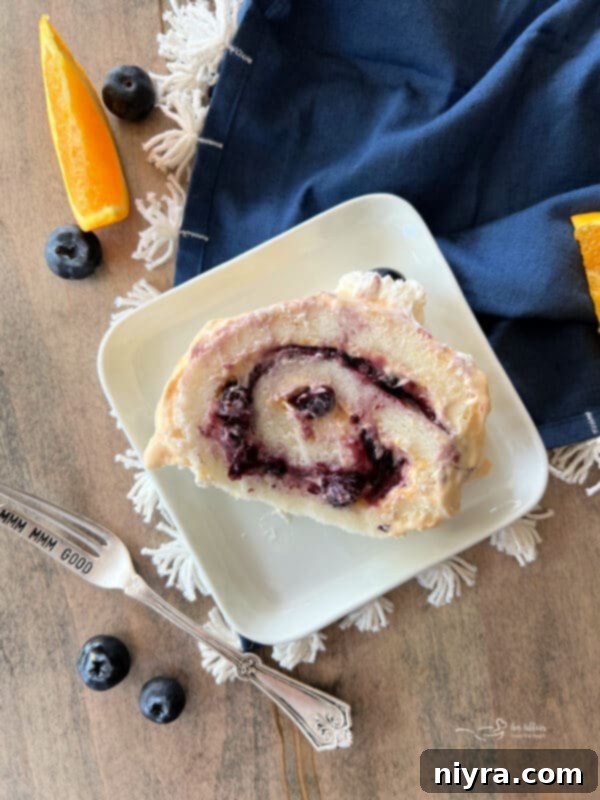 Angel Food Cake Roll with blueberry and orange filling, sliced and presented on a white plate