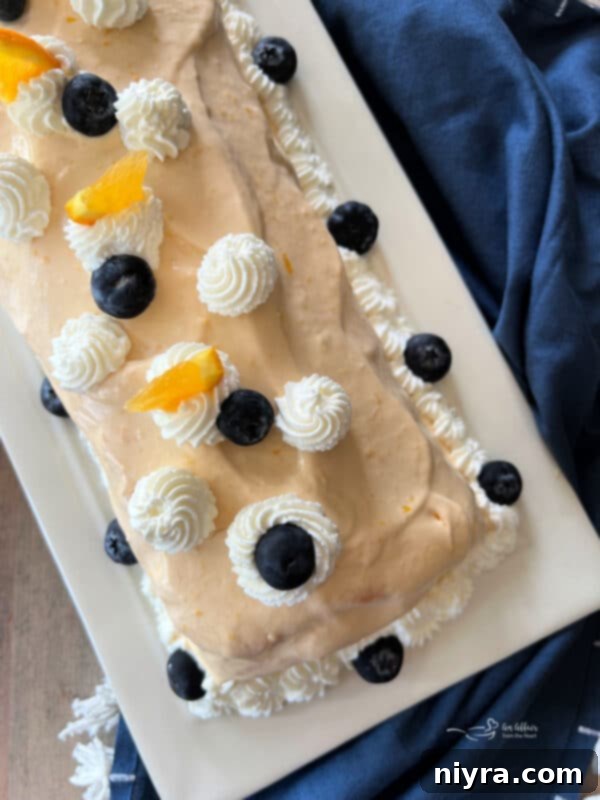 A beautifully decorated Blueberry Orange Angel Food Cake Roll, ready to be sliced and served