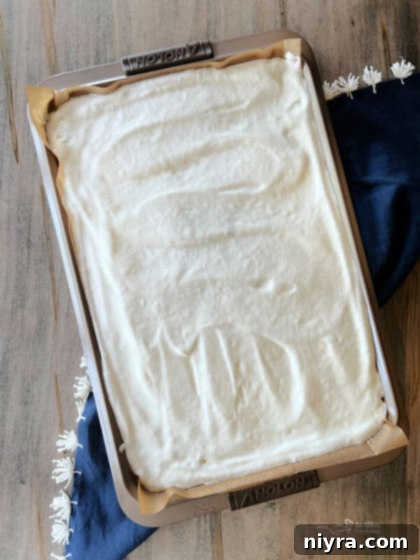 Angel food cake batter being mixed in a large bowl with an electric mixer