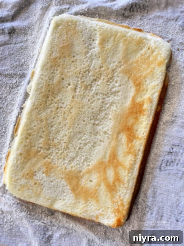Freshly baked Angel Food Cake cooling on a wire rack after being removed from the oven