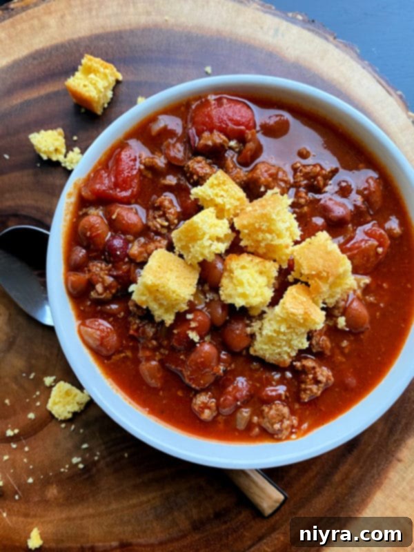 A serving of Three Bean Chili with cornbread, a classic comforting combination.