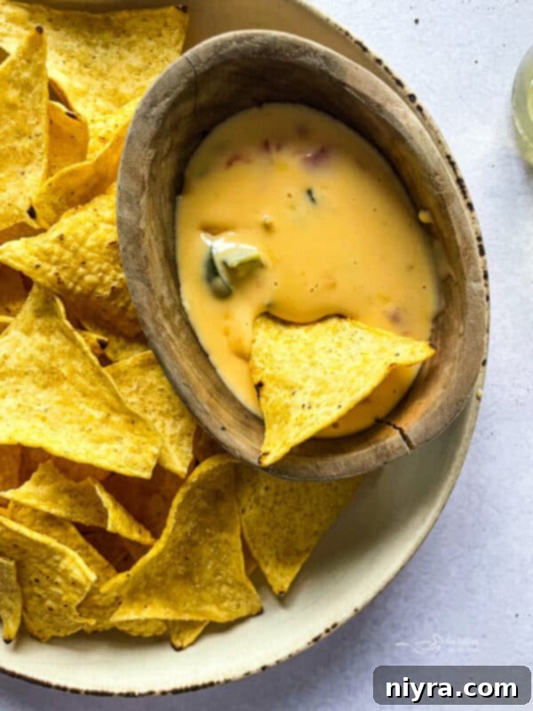 Rich, golden Copycat Qdoba Queso with tortilla chips