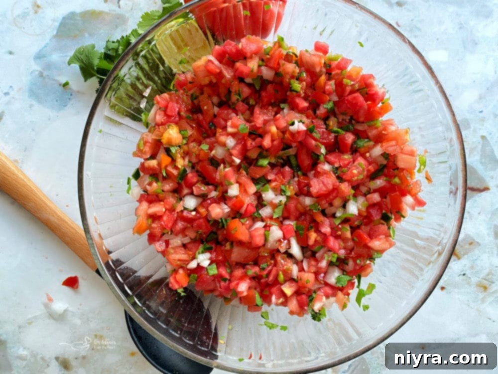 Overhead shot of a clear bowl filled with fresh Pico de Gallo
