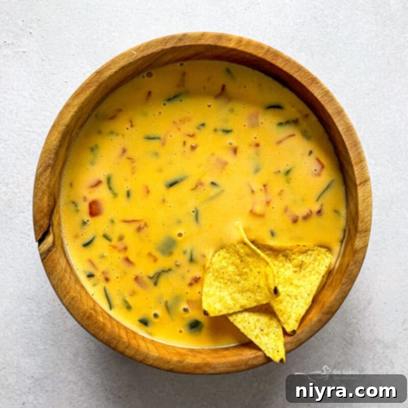 Tortilla chips generously dipped in homemade Qdoba Queso