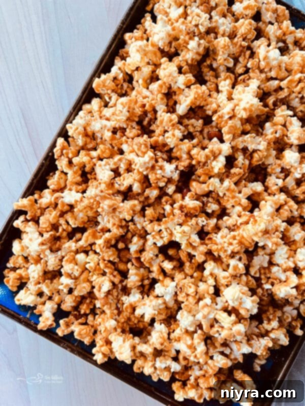 Ultimate Homemade Caramel Chocolate Nut Popcorn 16 Caramel-coated popcorn and nuts baking in the oven on a baking sheet