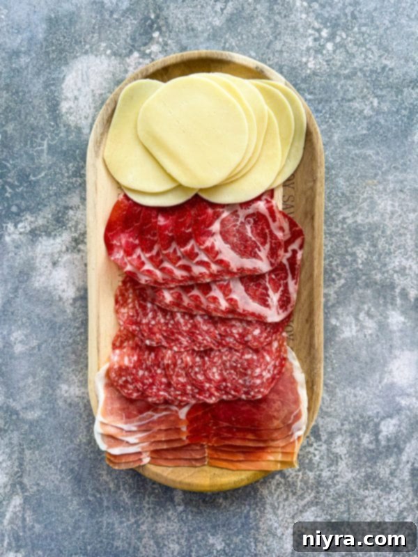 New Orleans Iconic Muffuletta 7 Layering meat and cheese on Muffuletta bread