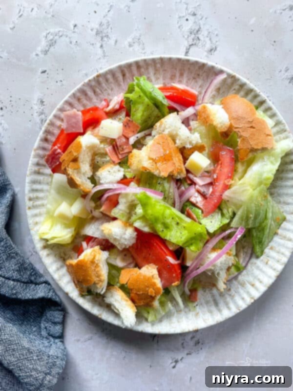 Delicious Little King Salad with deli meats, cheese, lettuce, tomatoes, and bread