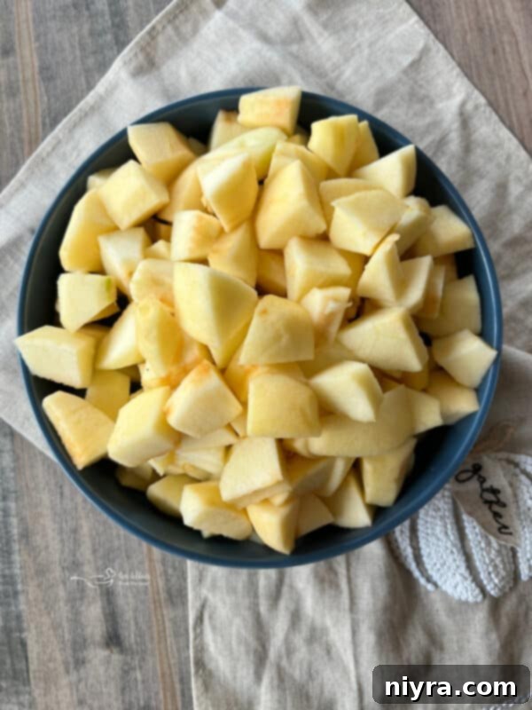 Peeled and cored apples on a cutting board