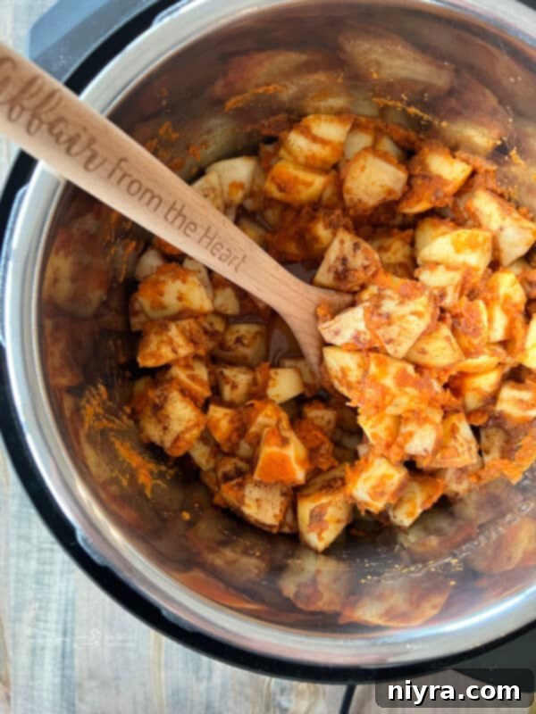 Close-up of apples and pumpkin puree in Instant Pot before cooking
