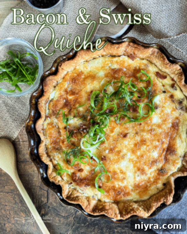 A beautifully presented slice of Bacon & Swiss Quiche, showcasing its layers and flaky crust.