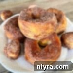 Pumpkin Spice Air Fryer Biscuit Donuts stacked on a white serving plate.