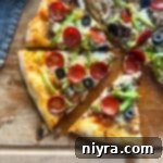 Supreme pizza slices on a wood board.