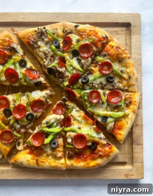 A supreme pizza baking in the oven, with cheese bubbling.