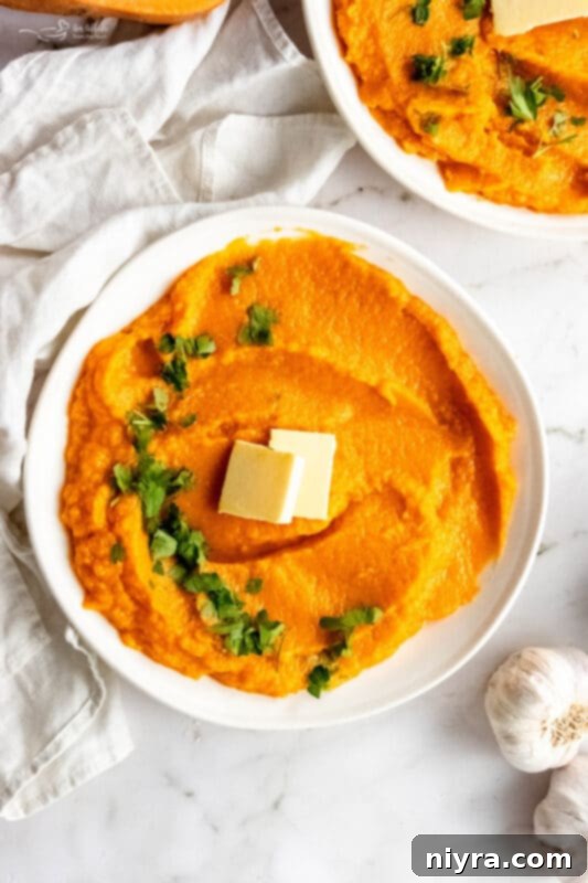 A vibrant bowl of Instant Pot Sweet Potato Mash, garnished with fresh herbs, against a rustic background.