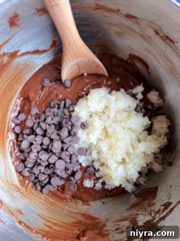 Cake batter being mixed with the dry ingredients and milk