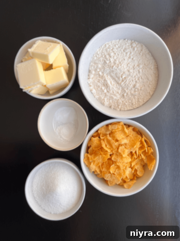 Two hands holding a cornflake crispy cookie over a stack of cookies.