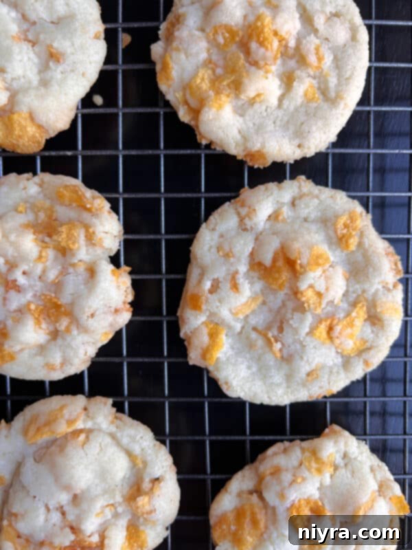 Golden brown cornflake cookies on a baking sheet with parchment paper