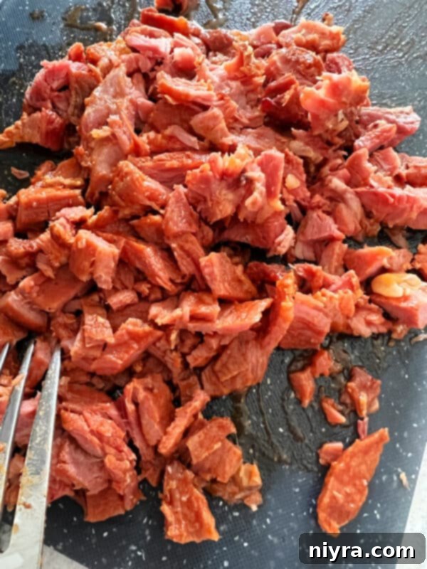 Grandmas Hearty Instant Pot Ham and Bean Soup 13 Shredded ham pieces on a cutting board, separated from the bone
