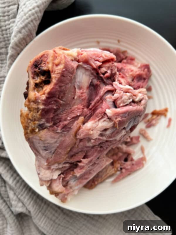 Grandmas Hearty Instant Pot Ham and Bean Soup 6 A large ham bone on a white plate, ready for soup making