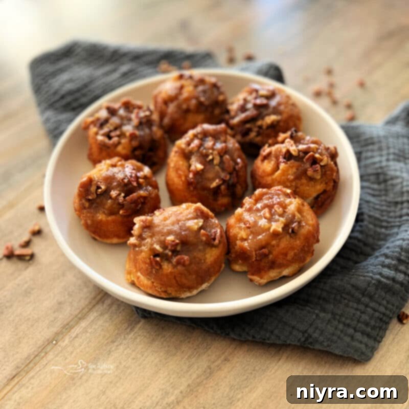 A plate of freshly baked Banana Pecan Sticky Rolls, garnished with a few whole pecans