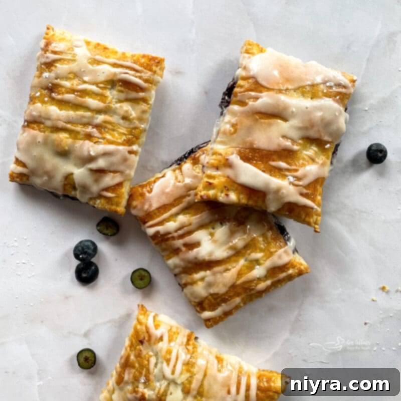 A plate of homemade blueberry toaster strudels, perfectly golden brown and ready for icing.