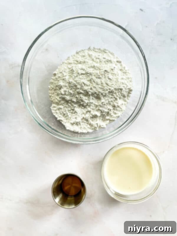 Ingredients for toaster strudel glaze: powdered sugar, almond extract, vanilla extract, and heavy cream.