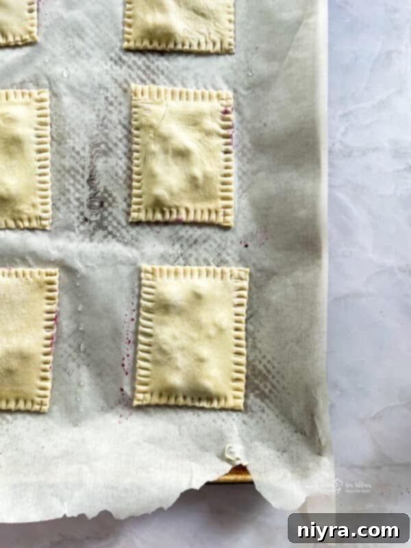 Homemade blueberry toaster strudels with sealed edges, ready for egg wash and baking.