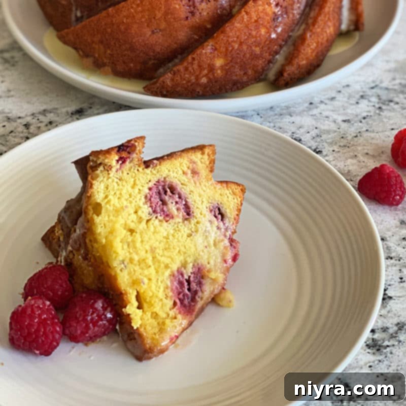 A beautifully sliced Lemon Raspberry Bundt Cake on a serving platter