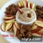 Creamy Apple Dip in a white serving bowl, surrounded by fresh apple slices and cinnamon grahams, with text "APPLE DIP"