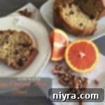 Overhead of a slice of bread on a white plate with text "Orange Cranberry Pecan Bread"