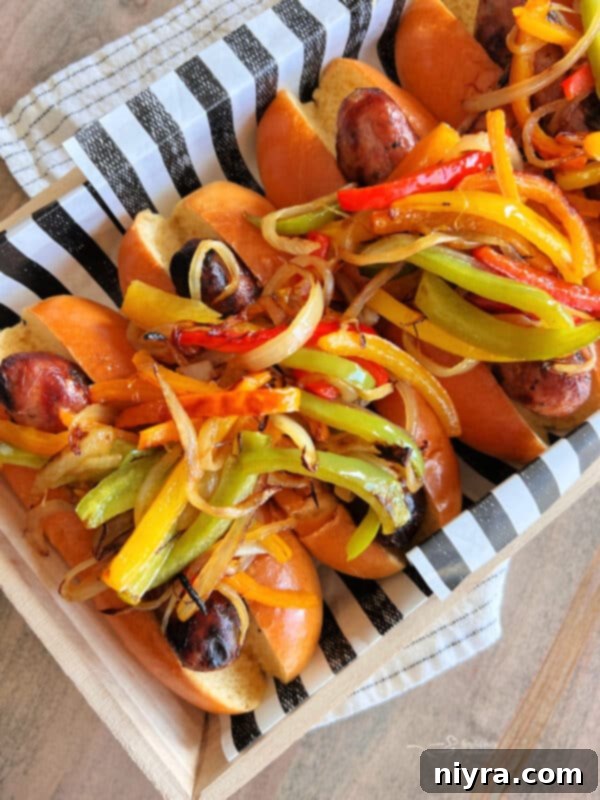 Sausage, peppers, and onions on a plate with a bun