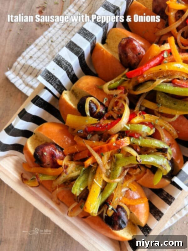 Classic Grilled Italian Sausages with Peppers and Onions on a dark plate