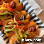 Italian Sausage with Peppers & Onions lined upon a decorative plate