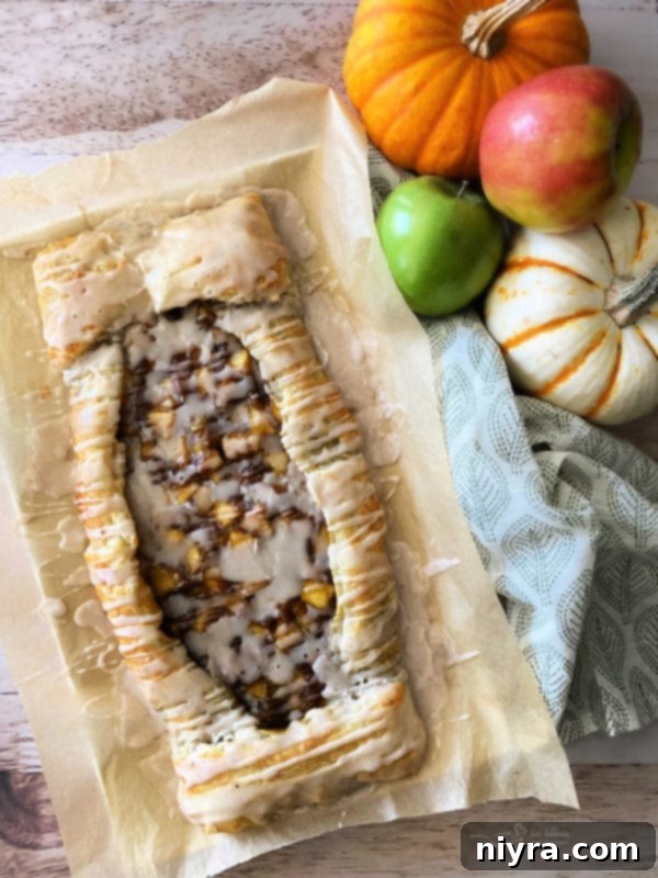 apple pumpkin strudel with icing on parchment paper