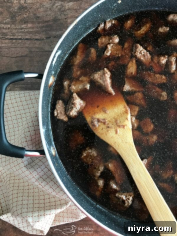 All the liquid ingredients for the gravy added to the skillet with browned beef tips, simmering.