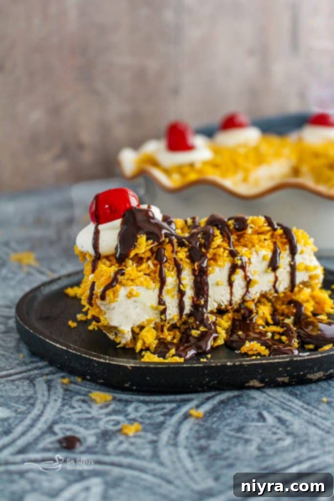 A slice of fried ice cream pie with whipped cream, cherry, and chocolate drizzle