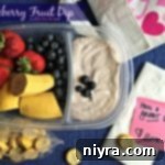 blueberry fruit dip and a variety of fruits in a container with text "blueberry fruit dip"