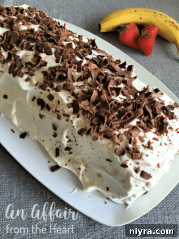 Banana Split Swirl Cake 3 An entire Banana Split Jelly Roll Cake, uncut, beautifully presented and ready to be sliced, showcasing its perfect roll and whipped cream topping.