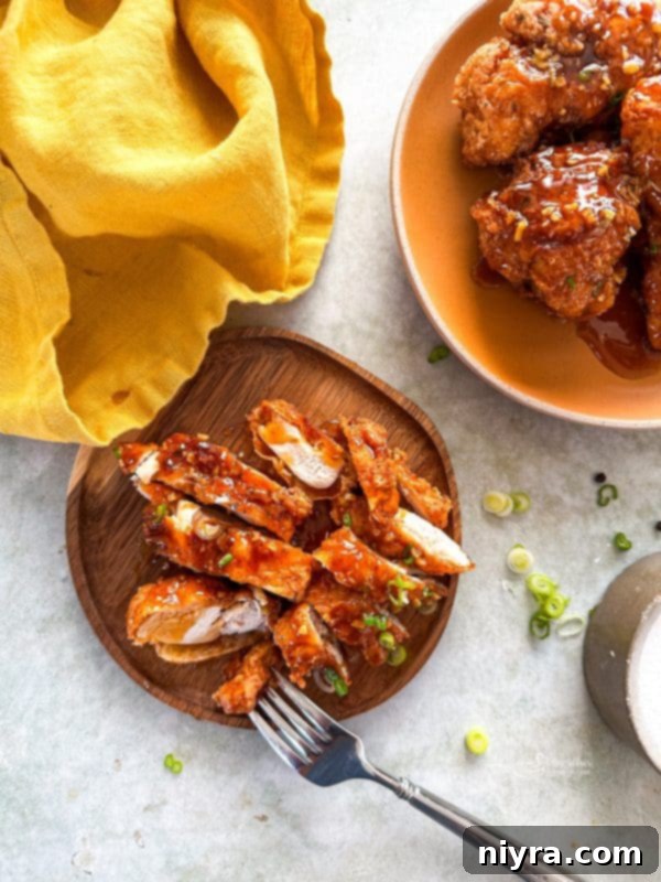 Close-up of crispy honey fried chicken pieces, showcasing their golden-brown exterior and glistening honey glaze.
