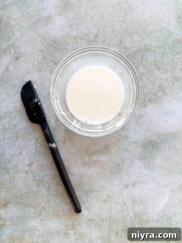 Honey, garlic, and soy sauce simmering in a saucepan over medium-high heat, starting the honey garlic sauce.