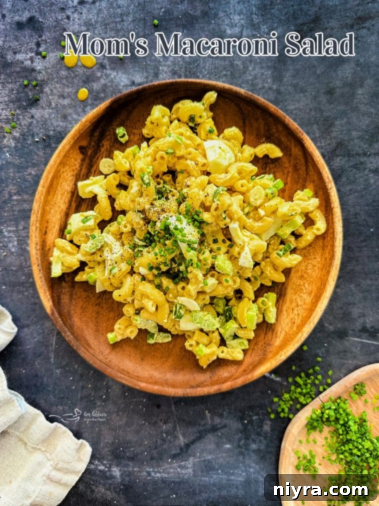A vibrant, close-up hero shot of Mom's Macaroni Salad in a rustic bowl.