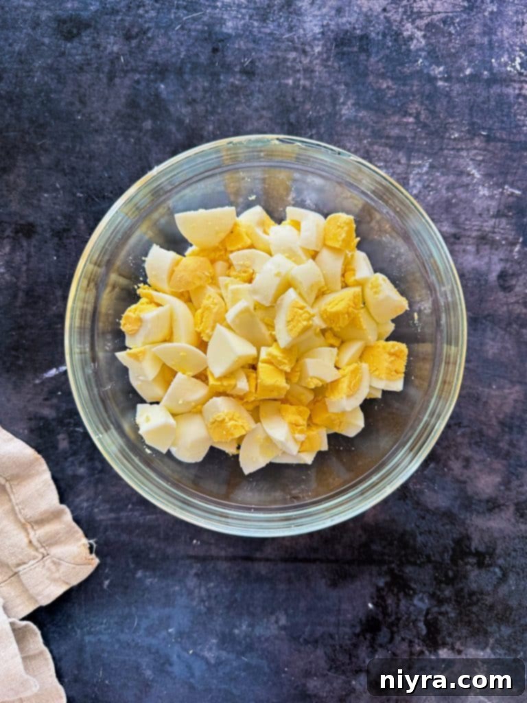 Cooked macaroni noodles being rinsed under cold water in a colander.