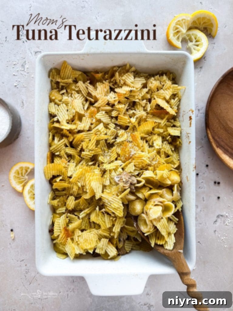A large serving of Tuna Tetrazzini Casserole with a spoon, ready to be dished out.