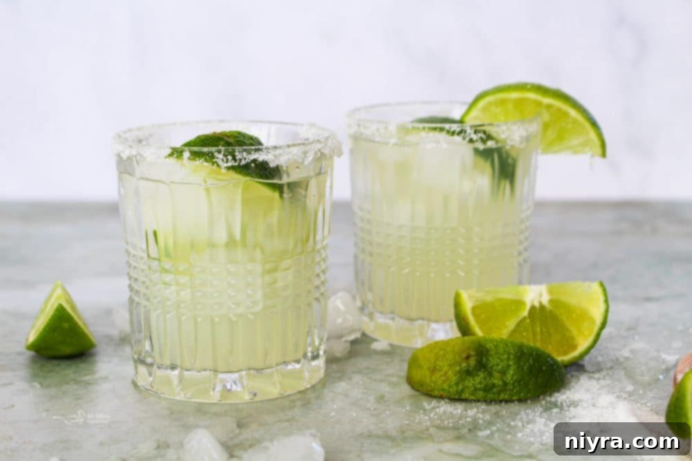Pouring a margarita into a glass from a pitcher