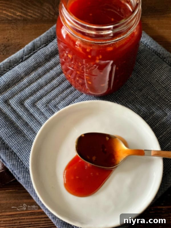 A close-up shot of a jar of homemade BBQ sauce, showcasing its rich texture and color.
