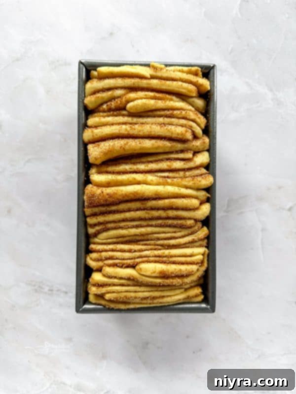 Warm Cinnamon Pull Apart Delight 13 Stacked cinnamon sugar dough strips ready to be placed in the pan