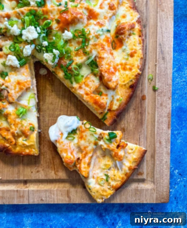 Close up of a single slice of buffalo chicken pizza with melted cheese